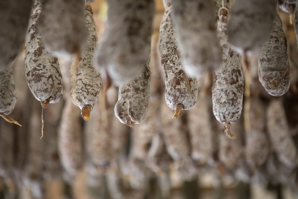 Rangée de saucissons aux cèpes suspendus.