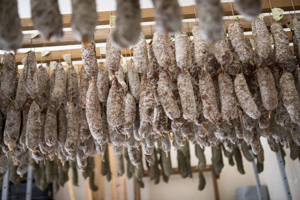 Multitude de saucissons suspendus en train de sécher.